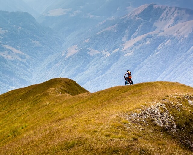 Person bicycling on hill